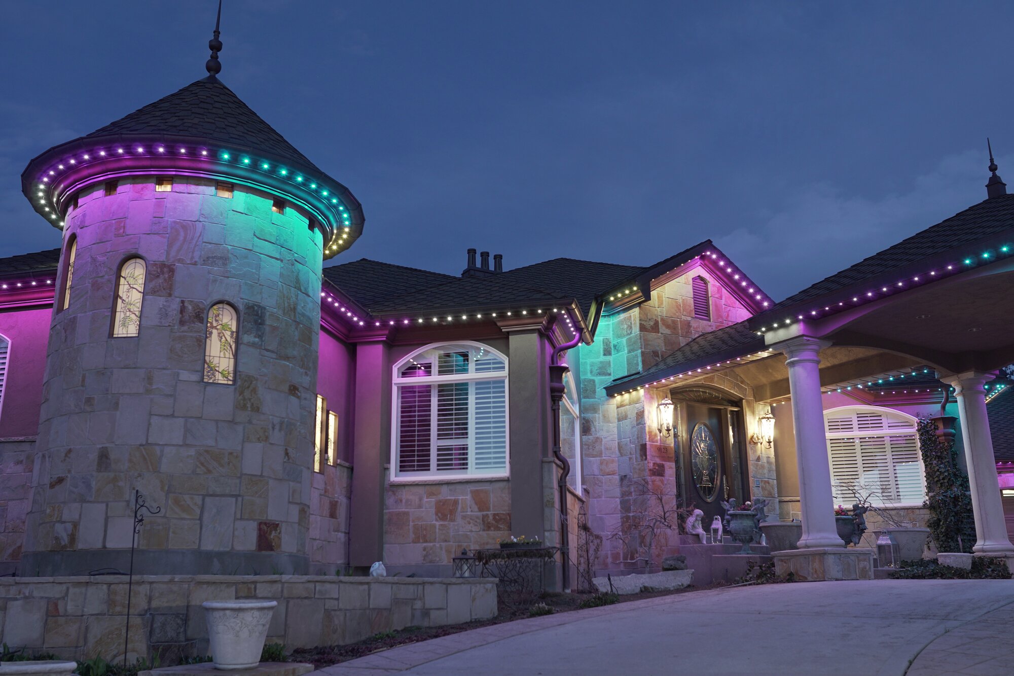 Luxury stone estate with purple and teal permanent lighting