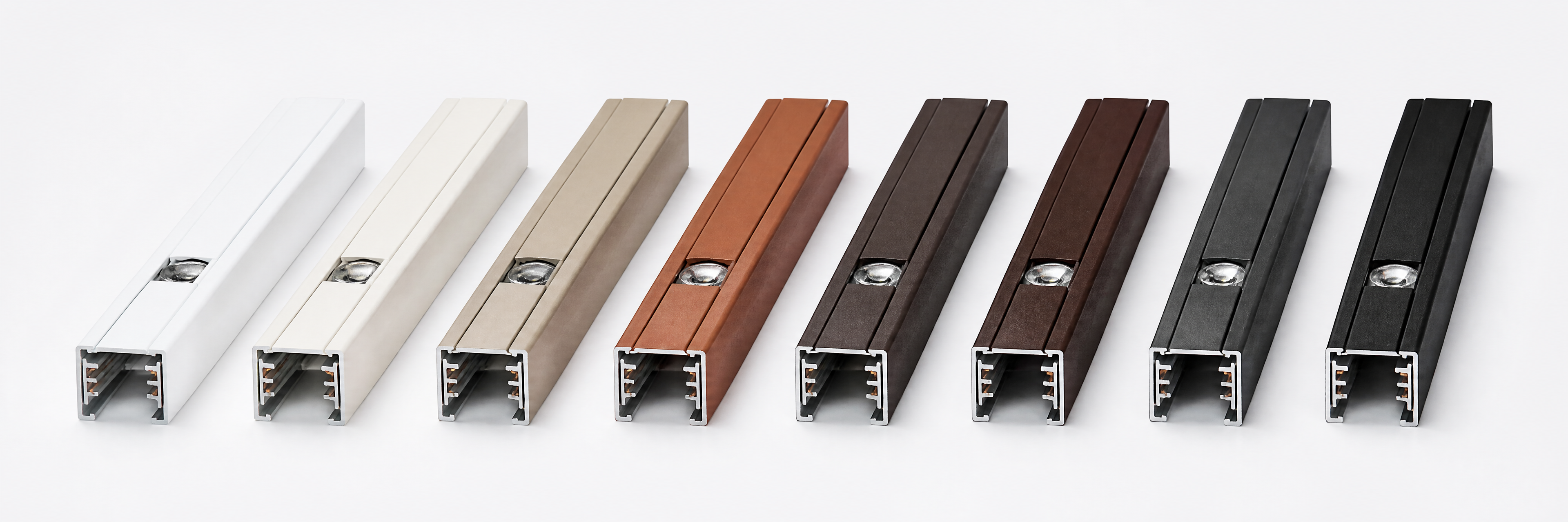 A row of aluminum lighting-track samples in different powder-coated finishes, from white and almond through bronze, brown, charcoal, and black
